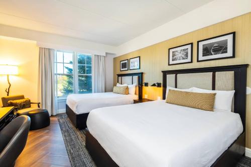 a hotel room with two beds and a window at Calabogie Peaks Resort, an Ascend Collection Hotel in Calabogie