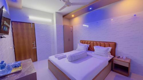a bedroom with a bed with white sheets and pillows at Hotel Sunrise Int in Dhaka