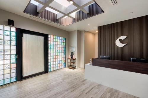 an office lobby with a reception desk and a sign on the wall at Comfort Suites Tijuana in Tijuana