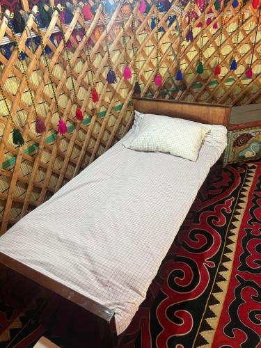 a bed in a yurt with a white comforter at Ak-Suu Eco House in Teploklyuchinskoye