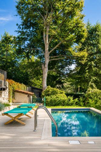 a swimming pool in a yard with a tree at Il Lavatoio in Cissano