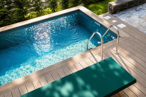 a swimming pool on a deck with a wooden deck at Il Lavatoio in Cissano