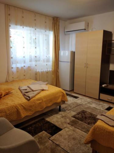 a small room with a bed and a refrigerator at Casa Petre in Eforie Nord