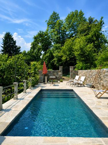 a swimming pool in a backyard with a table and chairs at Corte Villa Donati in Cissano