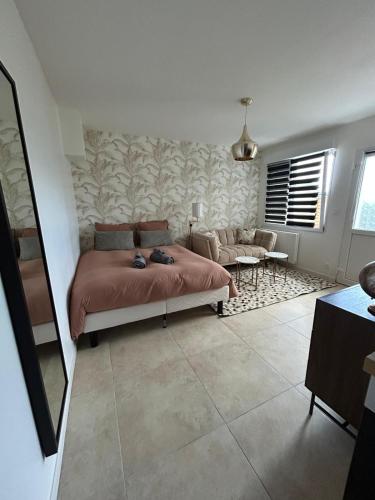 a bedroom with a bed and a living room at Piscine chauffée partagée avec terrasse privative in Joué-lès-Tours