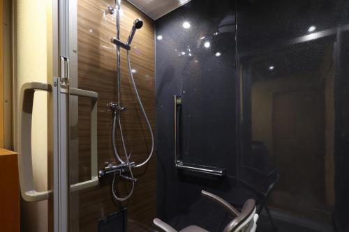 a bathroom with a shower stall with a toilet at Hotel Tamanoyu in Matsumoto
