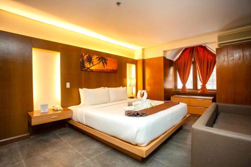 a hotel room with a large bed and a television at Crown Regency Beach Resort in Boracay