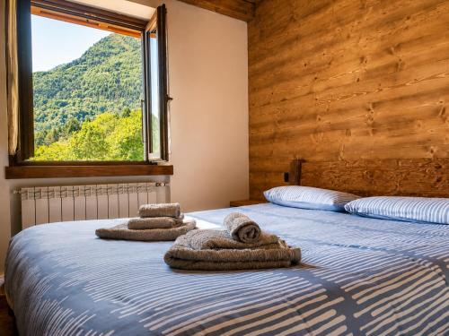 a bedroom with two beds with towels on them at SkyWood Chalet, Panoramic Mountain and Lake Views in Mello