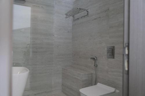 a bathroom with a shower and a toilet and a sink at Rose Beach 4 Durrat Alarous in Durat Alarous
