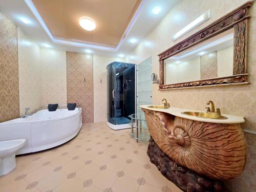 a bathroom with a tub and a sink and a bath tub at Вілла з 6 Спальнями Басейн Більярд Сауна BBQ Укриття in Odesa