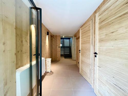 a hallway with wooden walls and a glass door at Paradis d'Ubaye - Terrasse - Plan d'eau - Jardin in Jausiers