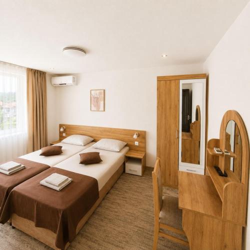 a hotel room with two beds and a mirror at Къща за гости КрисиЯна in Zlatograd