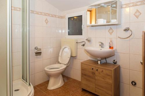 a bathroom with a toilet and a sink and a shower at Marea in Veli Lošinj