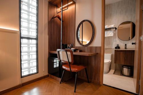 a bathroom with a chair and a sink and mirror at Nhiên Hotel in Ho Chi Minh City