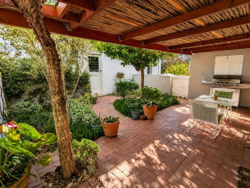 an outdoor patio with a brick floor and a grill at Old Corner Cottage in McGregor