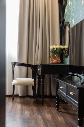 a desk with a chair and a mirror and a vase of flowers at Can Gio Park Hotel in Cần Giờ