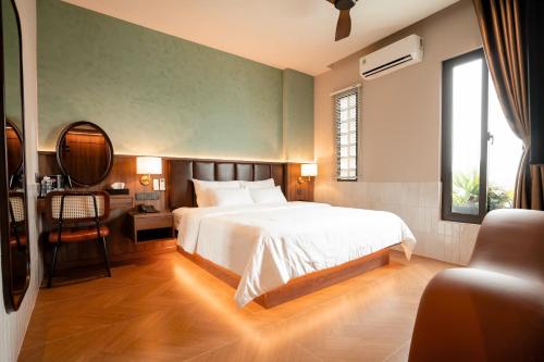 a bedroom with a bed and a table and a chair at Nhiên Hotel in Ho Chi Minh City