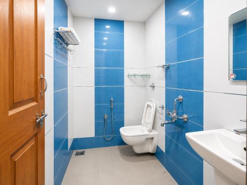 a blue and white bathroom with a toilet and a sink at Goa Villagio Hideaway in Majorda