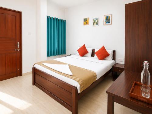a bedroom with a bed with a green curtain and a table at Goa Villagio Hideaway in Majorda