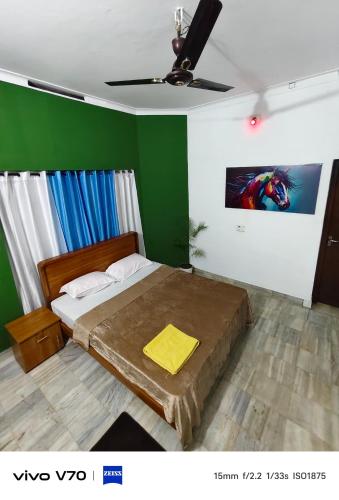 a bedroom with a bed and a green wall at Easystayhomestay in Kunnamangalam
