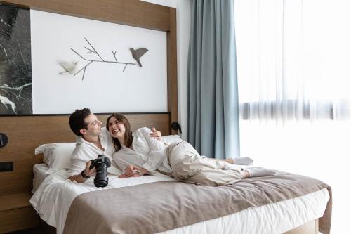 a man and a woman laying on a bed at IzaVera Luxury Suites - Vera in Heraklio