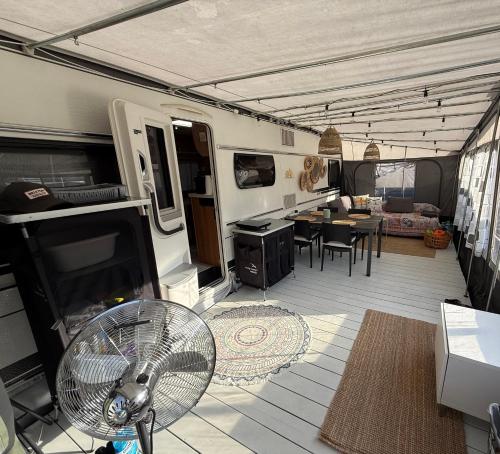 an rv with a fan and a kitchen and dining room at Przyczepa pod palemką in Jastarnia