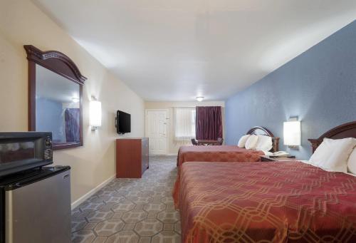 a hotel room with two beds and a television at Econo Lodge Thomaston in Thomaston