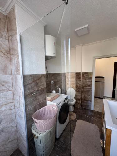 a bathroom with a toilet and a washing machine at Apartman Tuzla in Tuzla