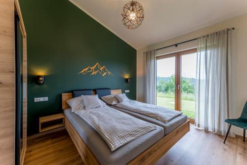 a bedroom with a large bed with a green wall at Auszeitquartier in Biedenkopf