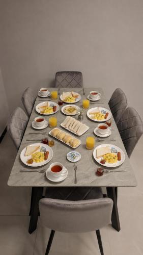 ein langer Tisch mit Tellern voller Essen darauf in der Unterkunft فندق جواهر العبدلي - Jawaher Hotel in Amman