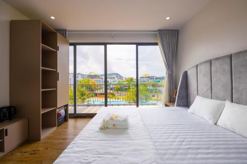 a bedroom with a large bed with a large window at TH Luxury Hotel 2 in Phú Quốc