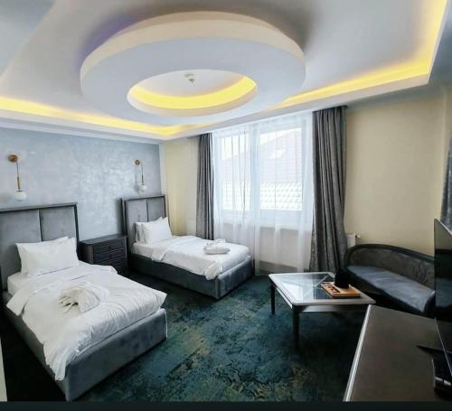 a hotel room with two beds and a couch at Deny Inn Harmony in Zărneşti