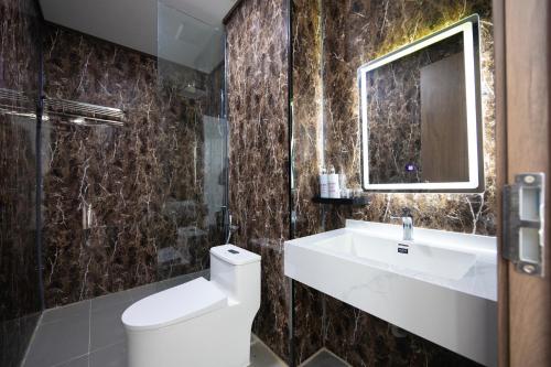 a bathroom with a toilet and a sink and a mirror at TH Luxury Hotel 2 in Phú Quốc