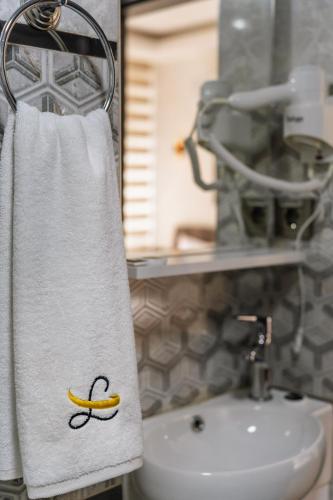 a towel with a banana painted on it hanging next to a sink at Marine Point Hotel & Antalya in Antalya