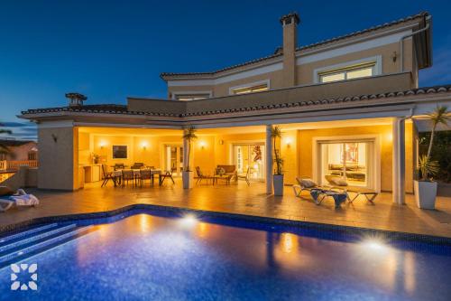 a large house with a swimming pool in front of it at Villa Esplendida by Abahana Villas in Ifach
