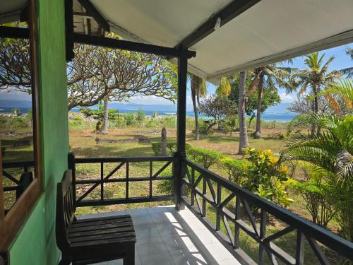 a porch of a house with a view of the ocean at Hotel Puma Bungalow in Huu