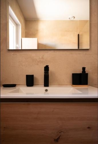 a bathroom counter with a sink and a mirror at Azure méditerranée in Sérignan