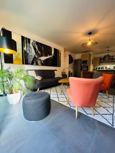 a living room with a couch and a chair at L'Hermine terrasse et parking, 500 plage in Concarneau
