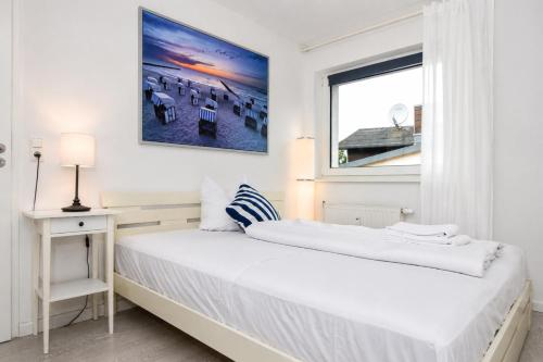 a white bedroom with a bed and a window at Kirchenplatz 6 Apartment 18 Atlantic in Warnemünde