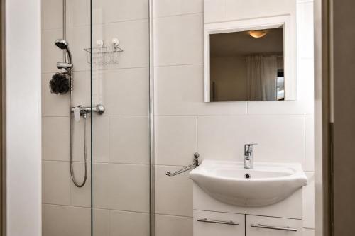a white bathroom with a sink and a shower at Kirchenplatz 6 Apartment 18 Atlantic in Warnemünde