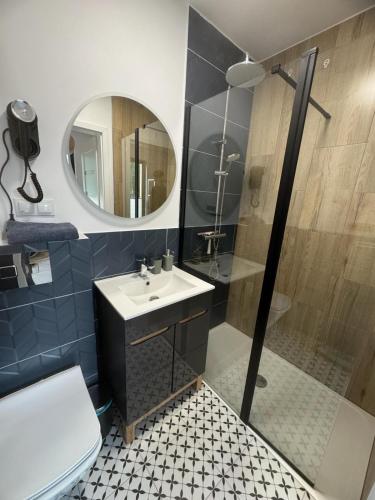 a bathroom with a sink and a shower with a mirror at Liwia Park Green House in Niechorze