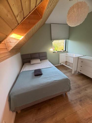 a bedroom with a large bed with a wooden ceiling at Liwia Park Green House in Niechorze