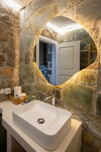 a bathroom with a white sink and a mirror at Helios stone house in Aegina