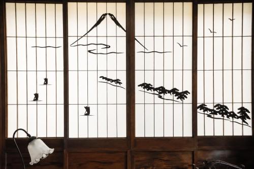 a door with birds on it with a fence at 三ツ峠の宿 in Nishikatsuracho