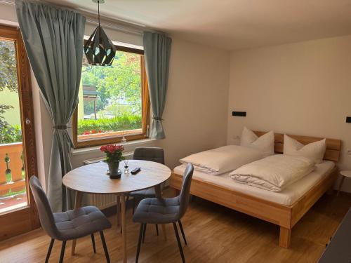 a bedroom with a bed and a table with chairs at Appartementhaus Grocke in Wagrain