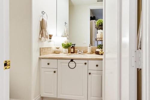 a white bathroom with a sink and a mirror at Morning Glory Retreat-Private Lux 1-Bedroom Suite in a Tropical Resort Setting in Vista