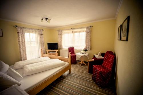a bedroom with a bed and a living room at Berghotel Zugspitzblick in Zöblen