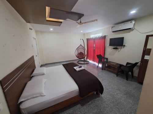 a bedroom with a large bed and a desk in it at mythriinn in Araku