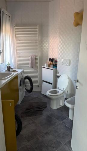 a white bathroom with a toilet and a sink at La CASA DI ALE in Imola