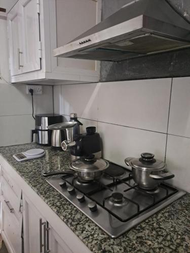 a kitchen with a stove with pots and pans on it at Authentic South in Mahébourg